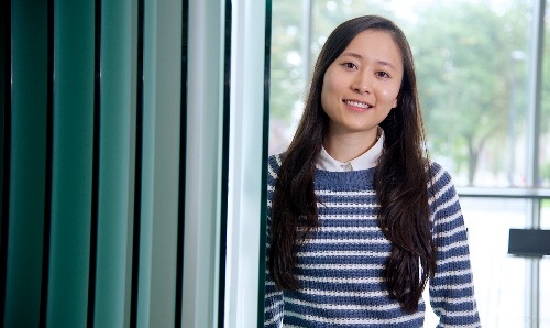 A student standing and smiling.