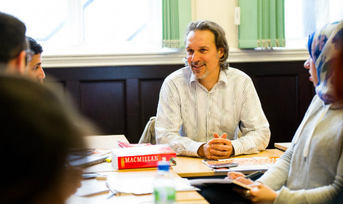 A member of staff talking to students.