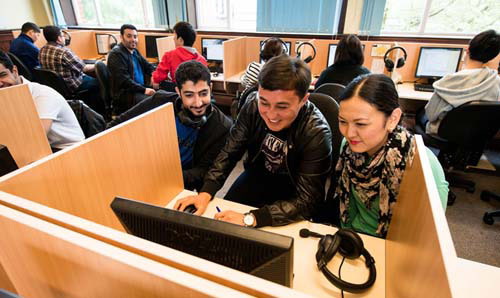 Students watching screen in media facility.