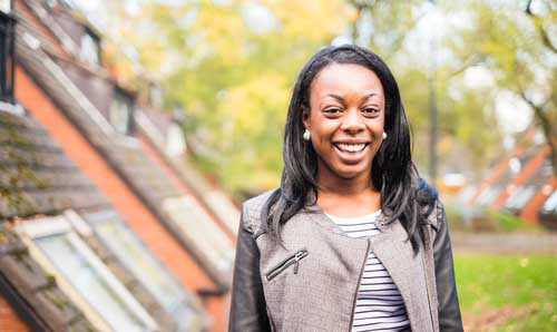 Smiling student next to a university building.